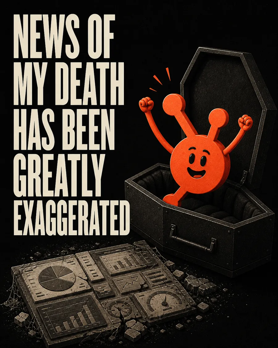 A cartoon red mascot throwing its arms up out of an open coffin, above a cracked stone slab carved with dashboard charts, under the words “news of my death has been greatly exaggerated.”